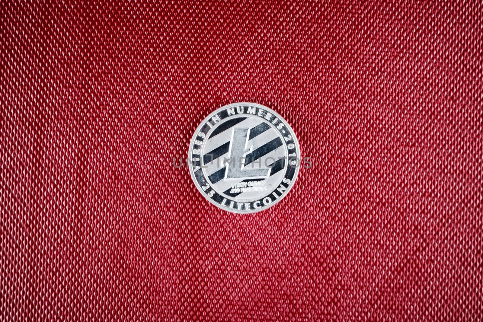 Digital currency physical silver litecoin coin on the red background