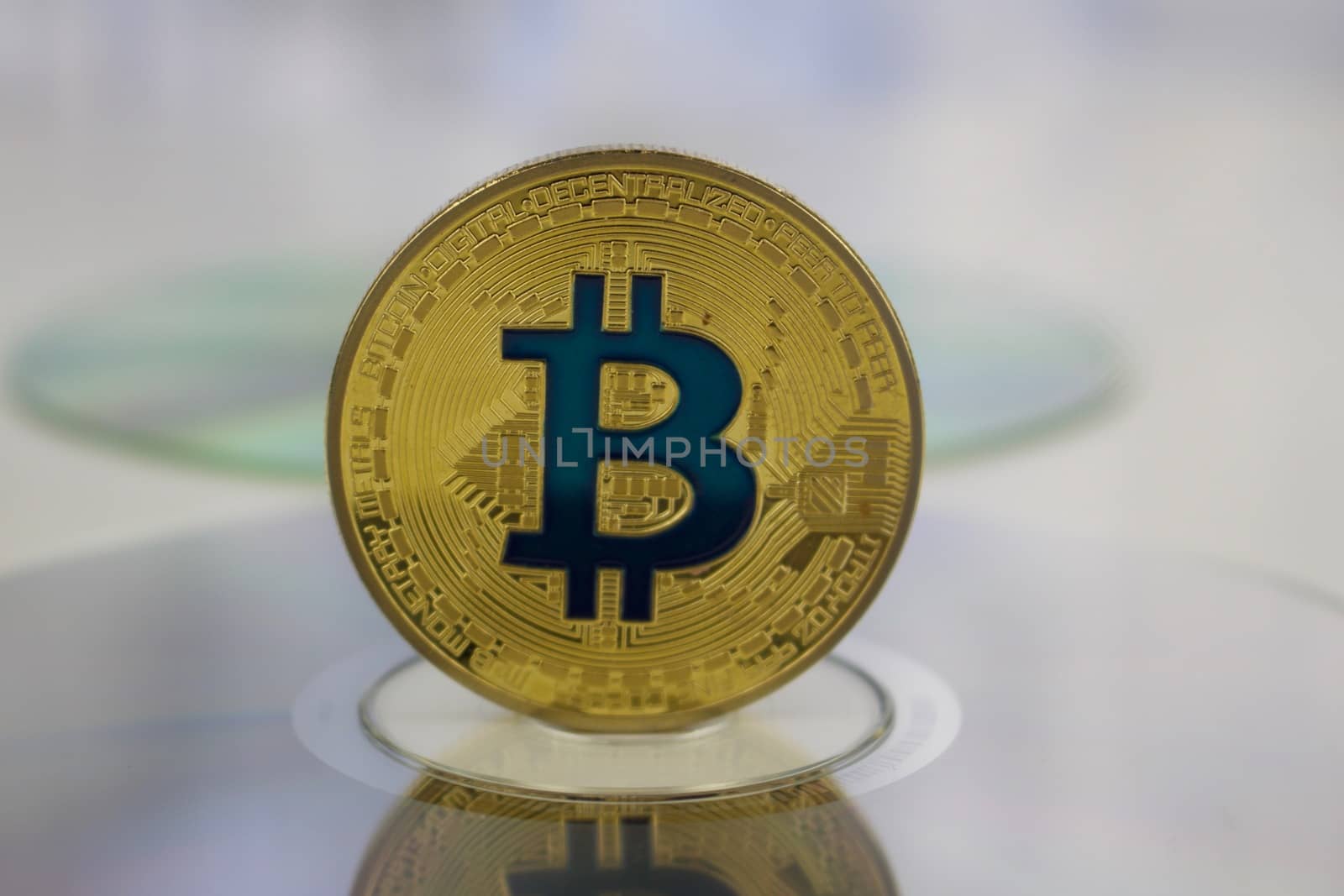 Digital currency physical gold bitcoin coin on CD. Financial concept.