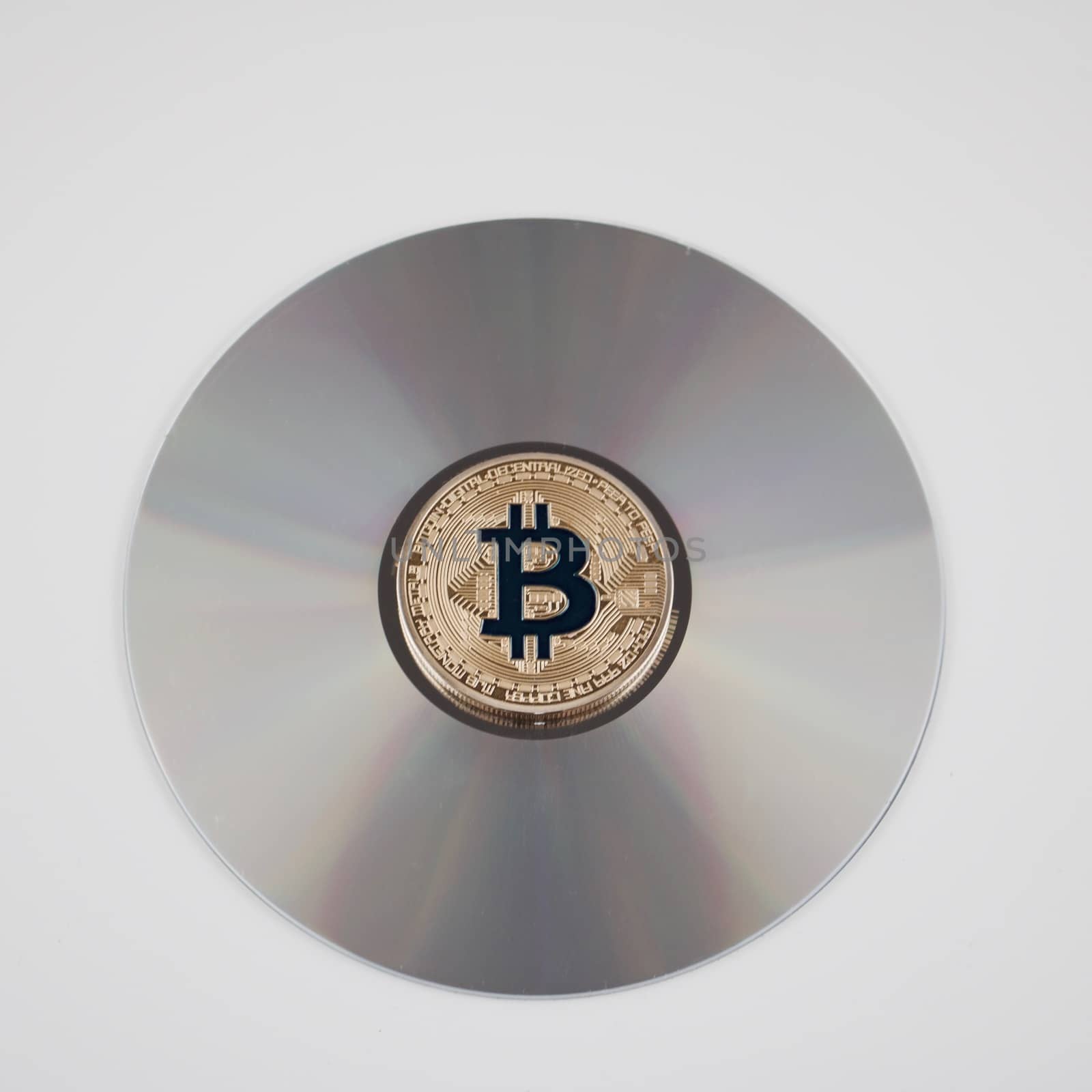 Digital currency physical gold bitcoin coin on the CD. Financial concept.