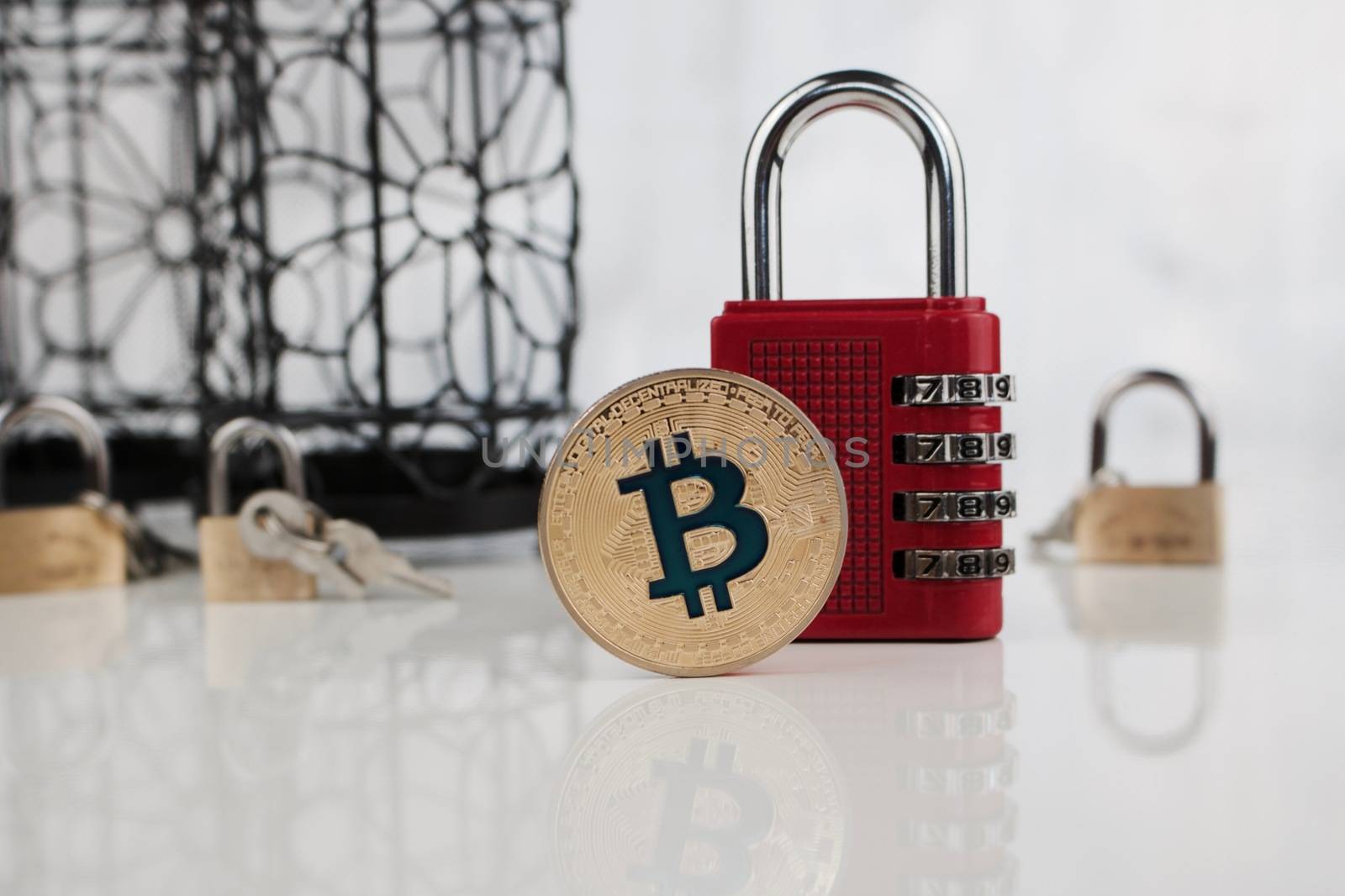 Digital currency physical gold bitcoin coin near red numeric padlock.