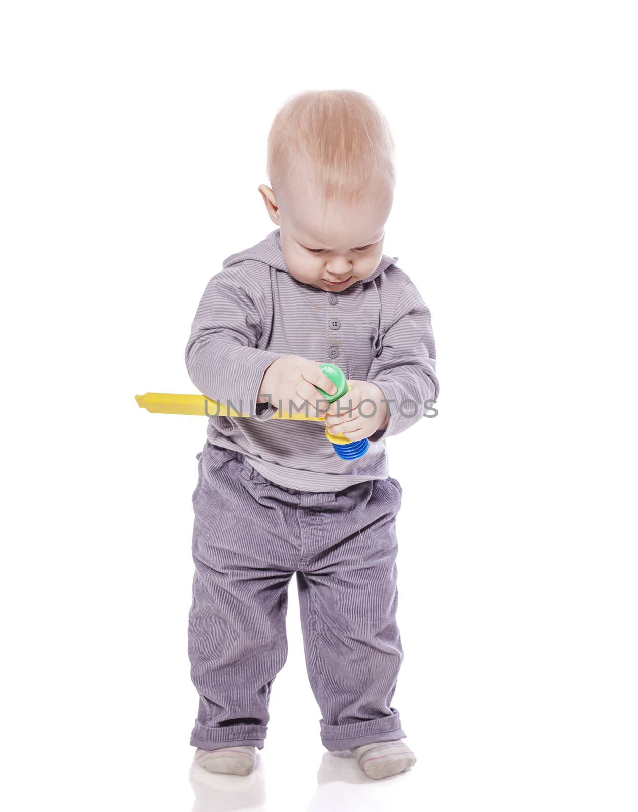 Toddler boy standing holding toy hummer isolated on white