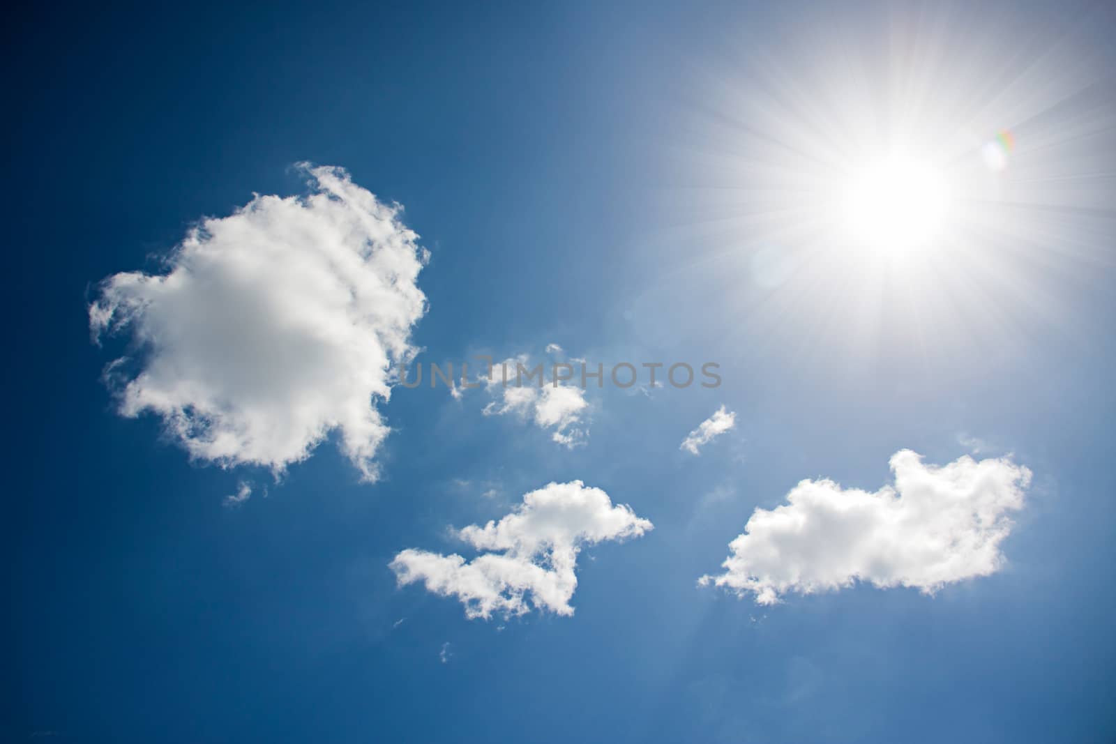 sunlight reflex above white clouds with blue sky