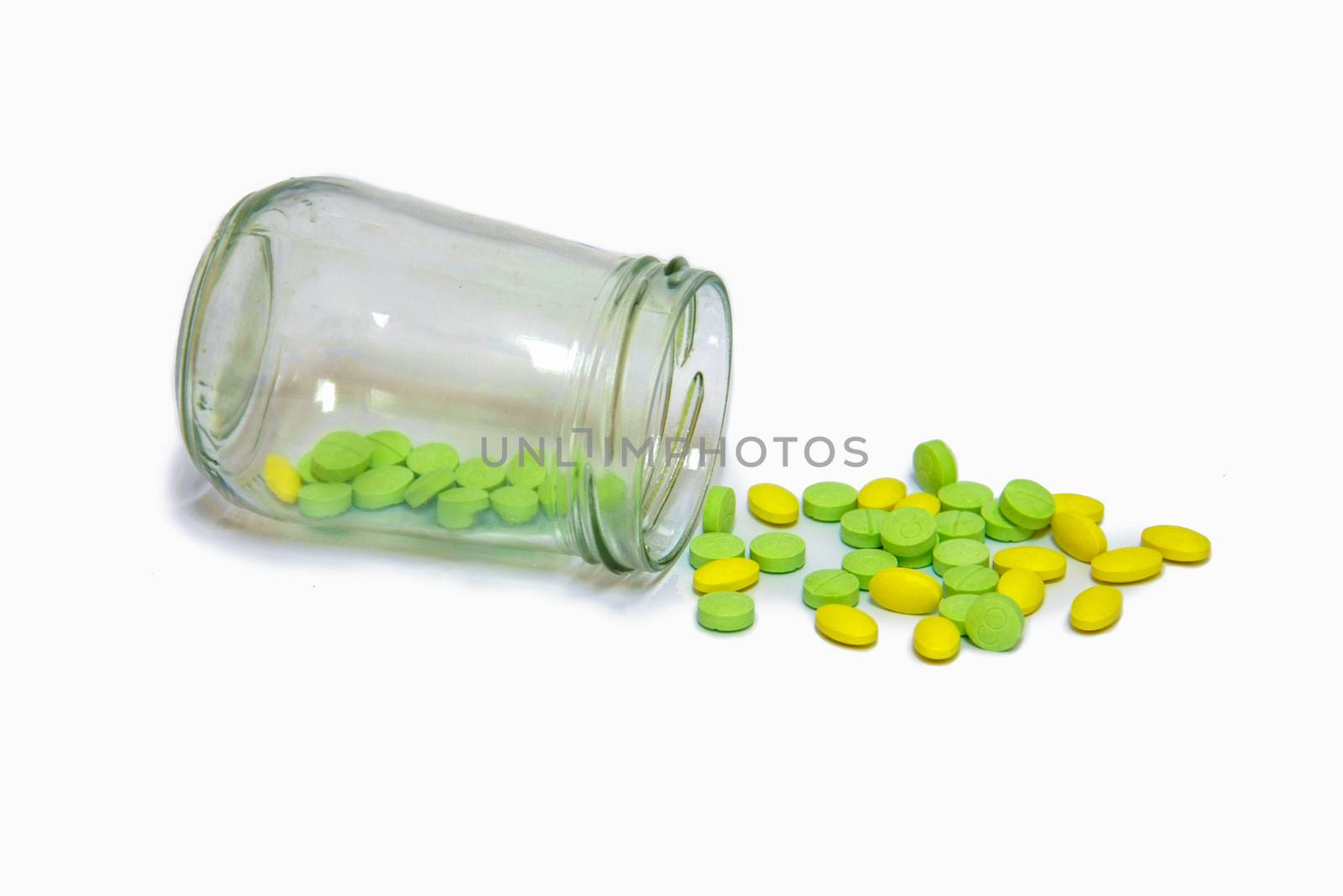 green and yellow pills medicine was pouring from glass bottle