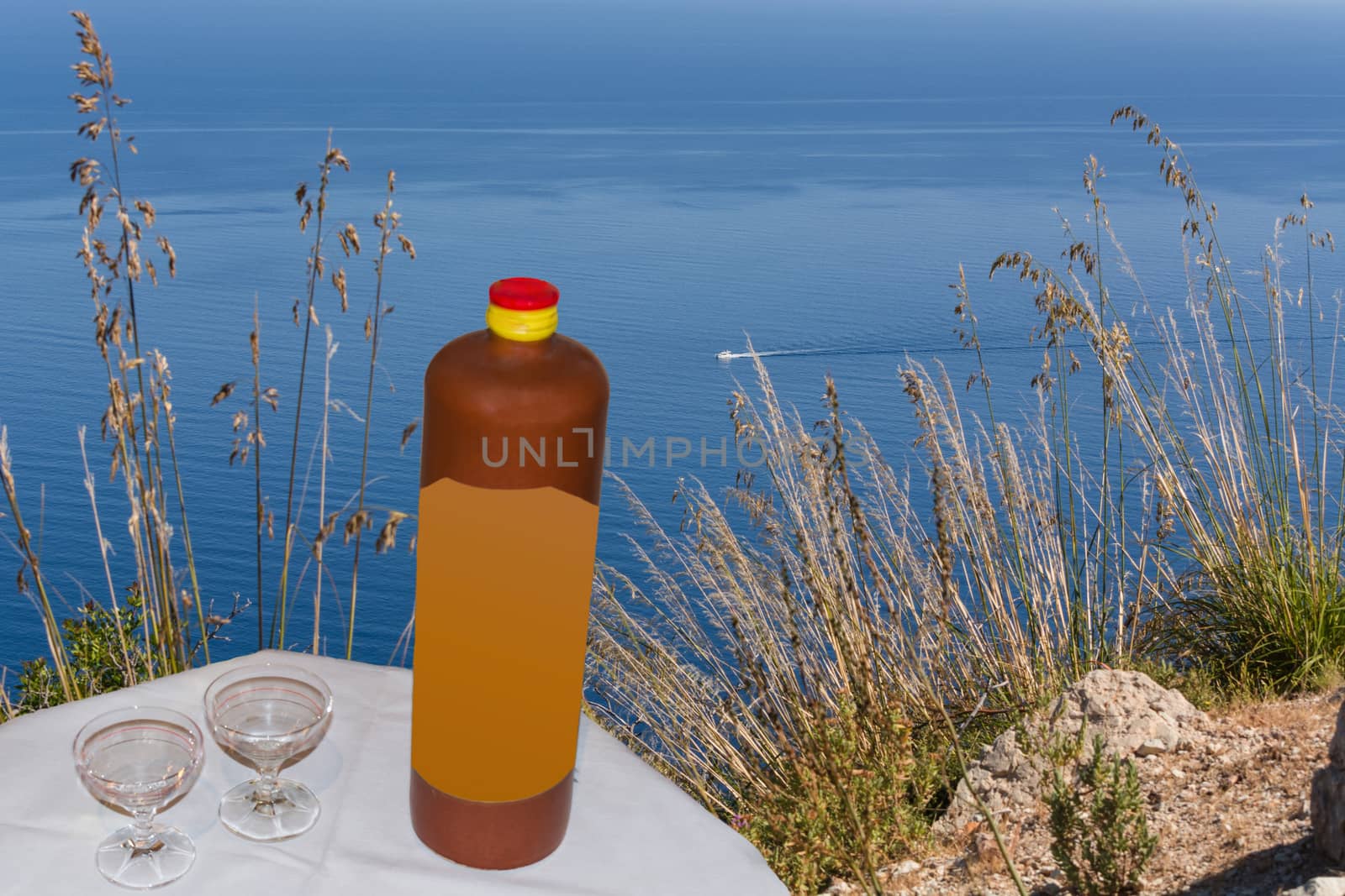 Stoneware bottle, two liqueurs, in the background sea.           by JFsPic