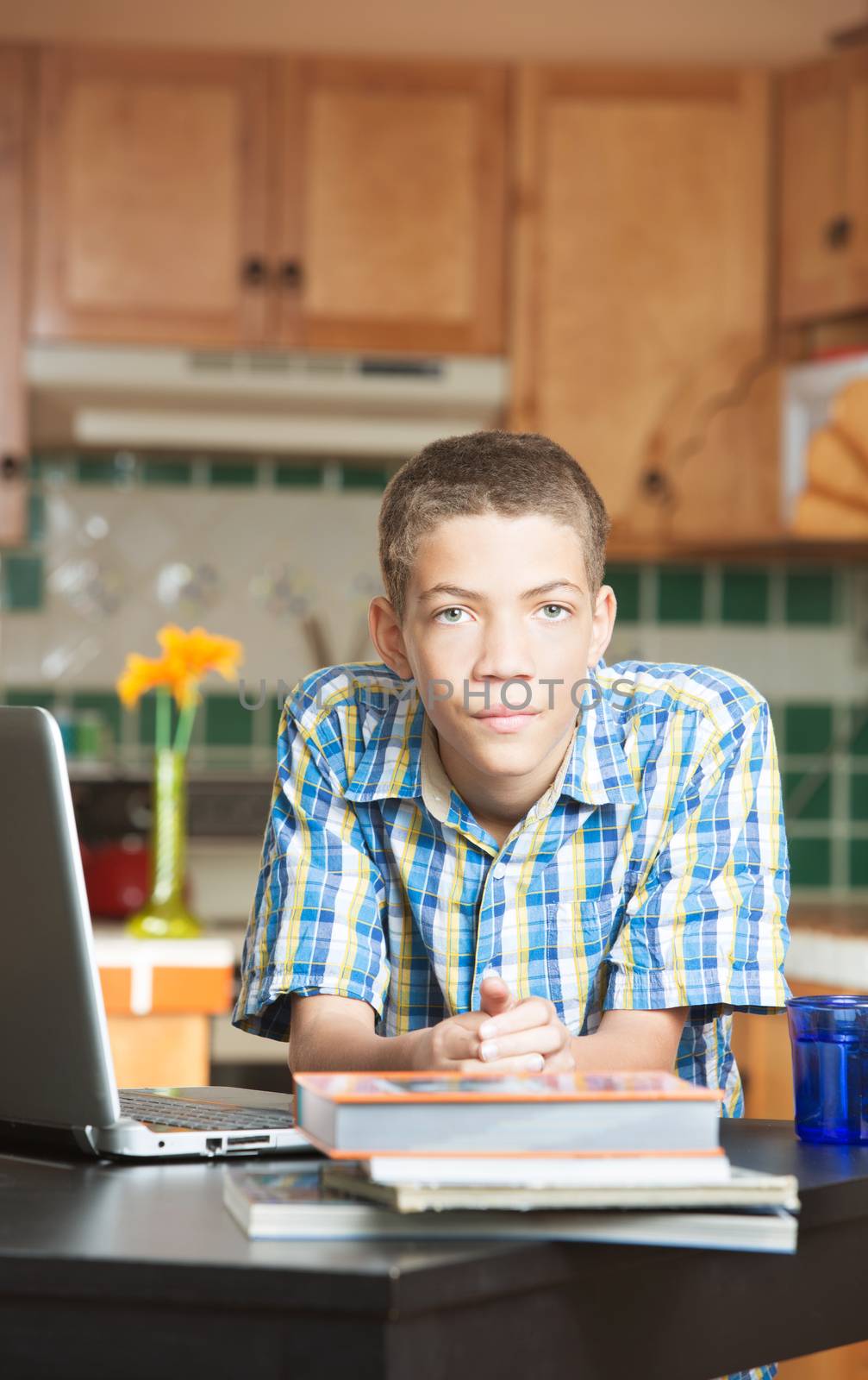 Calm teen with books and computer on table by Creatista