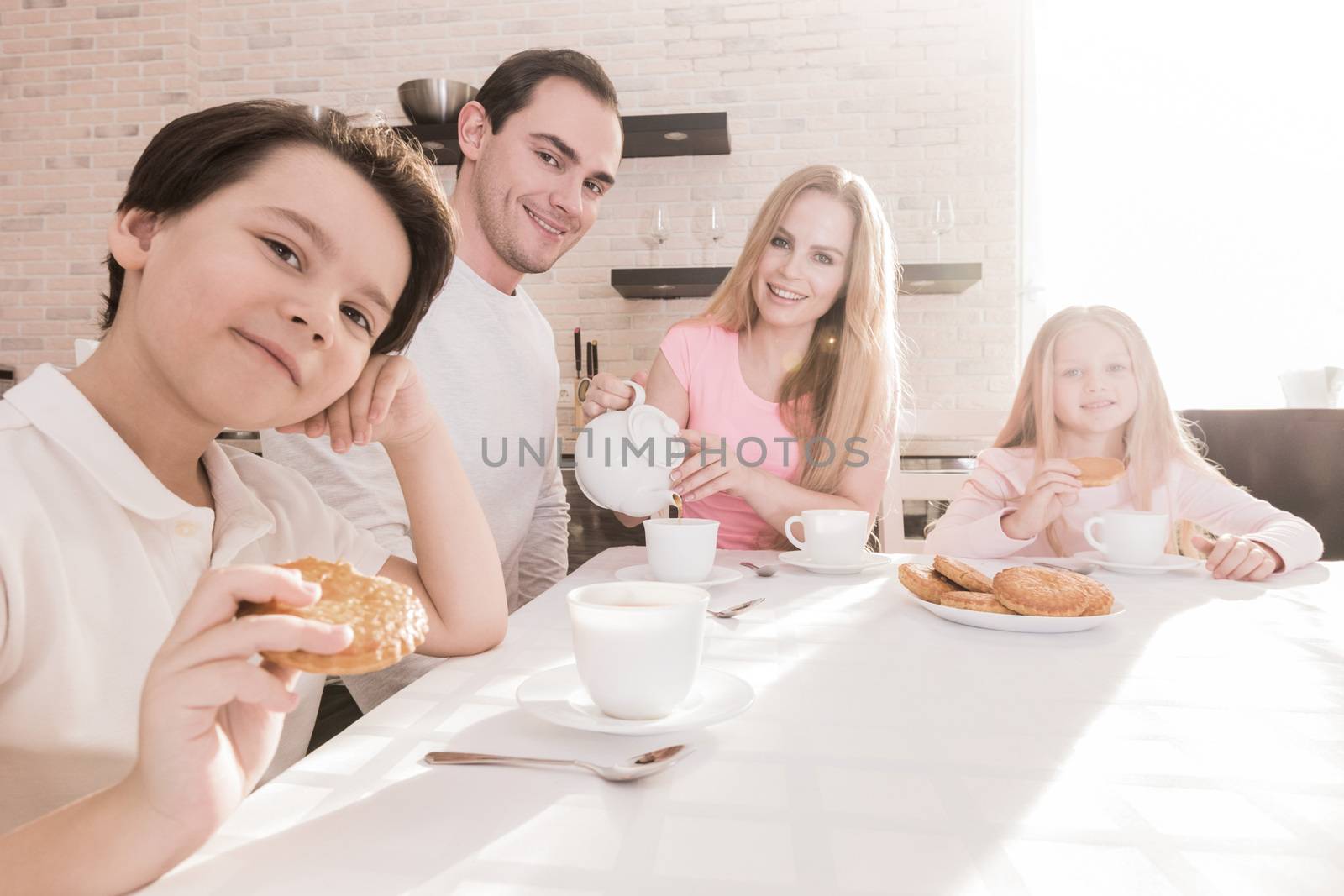 Happy family with children having breakfast at home