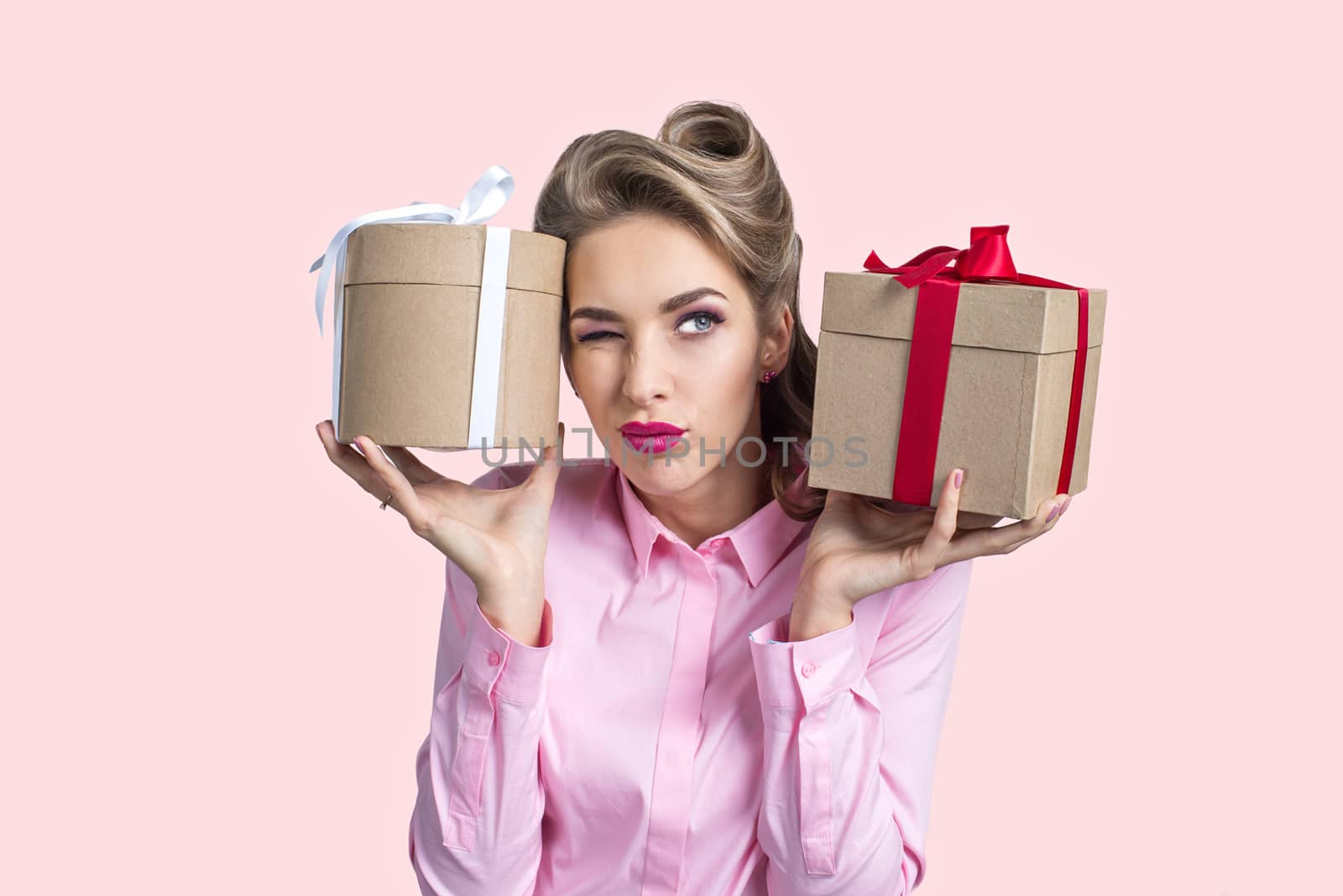 Young woman puts her ear to the presents with bows