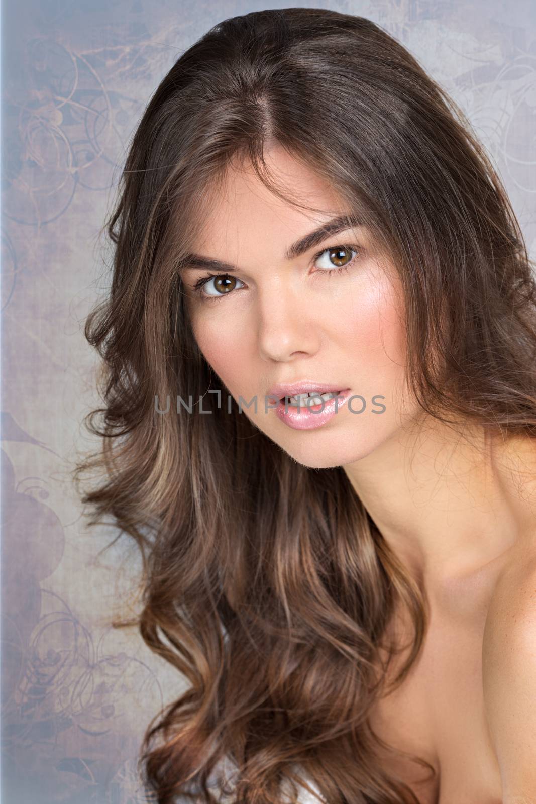 Studio portrait of a pretty woman with wavy fair hair and natural make-up