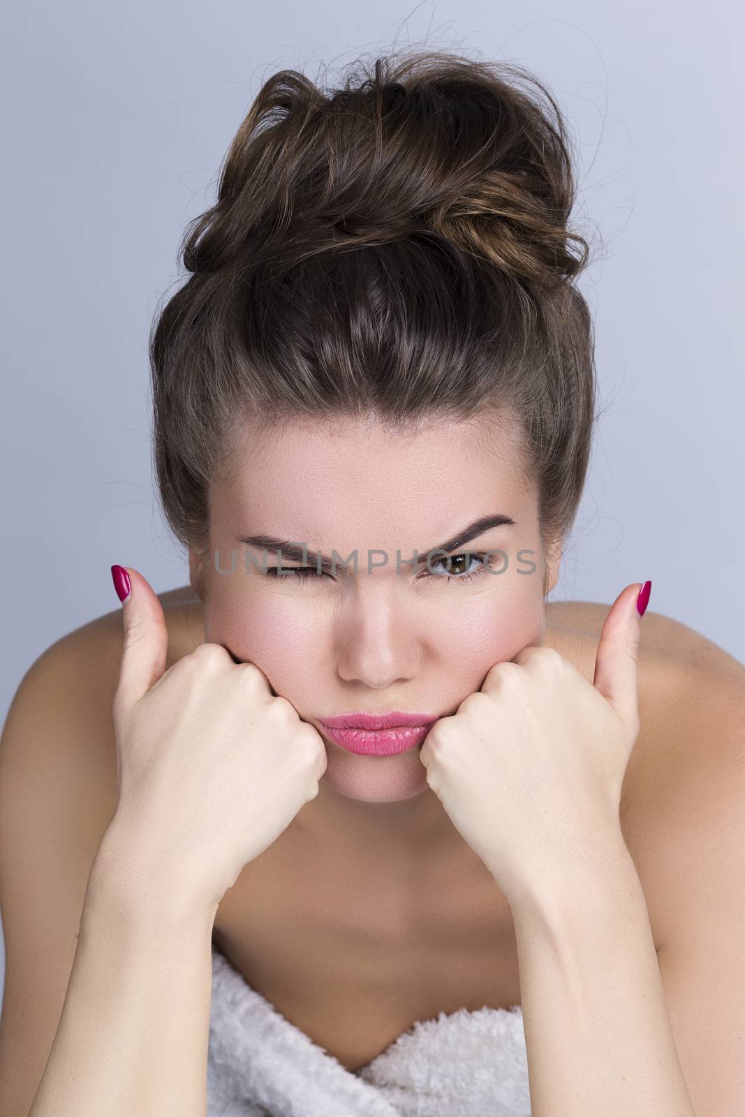 Clooseup portrait of beautiful young girl blowing her cheeks