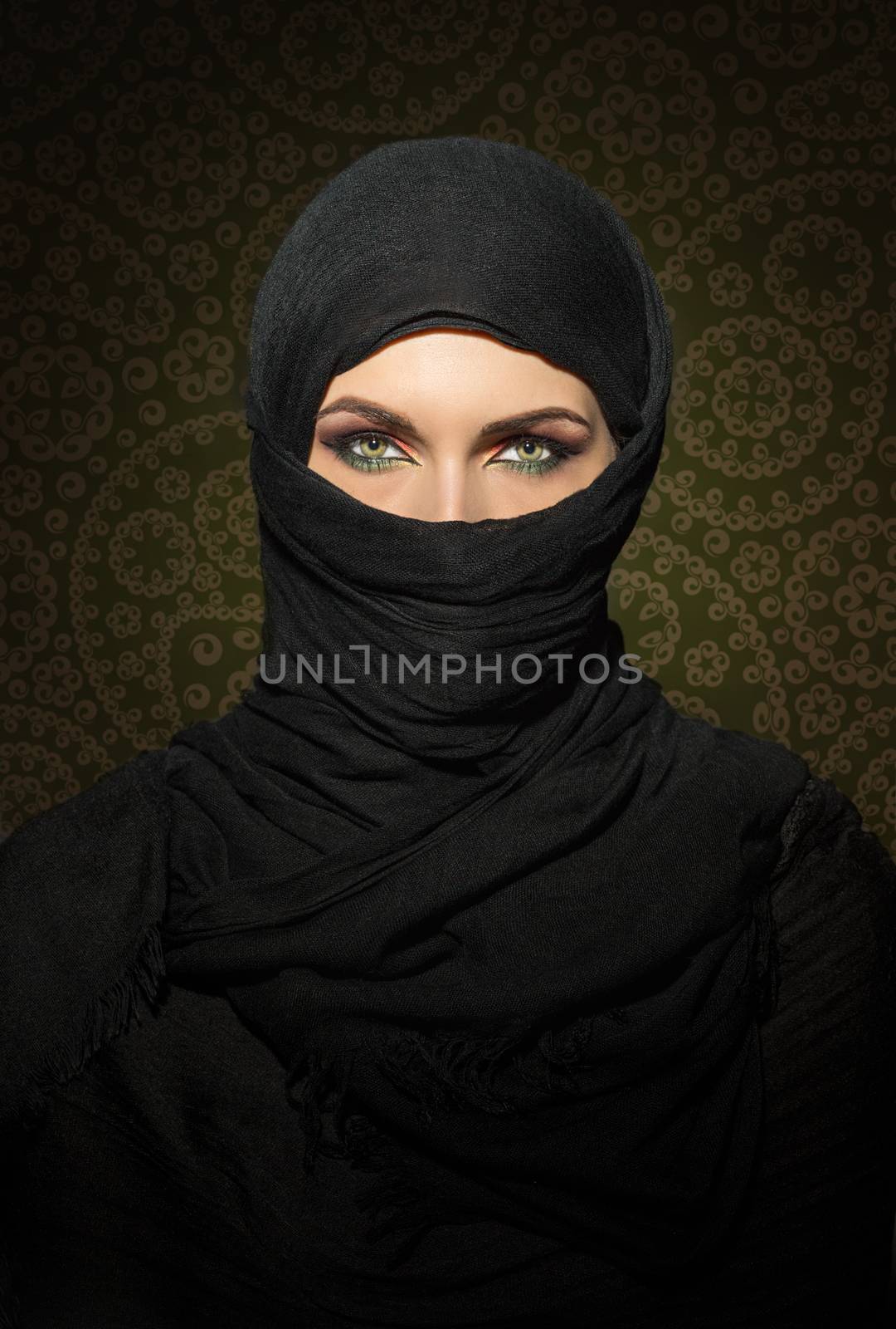 Beautiful muslim woman in niqab traditional veil against on dark background