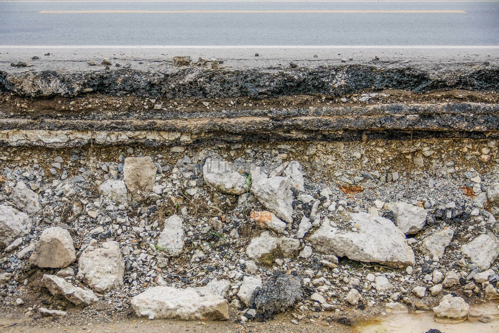 broken asphalt layer road with water