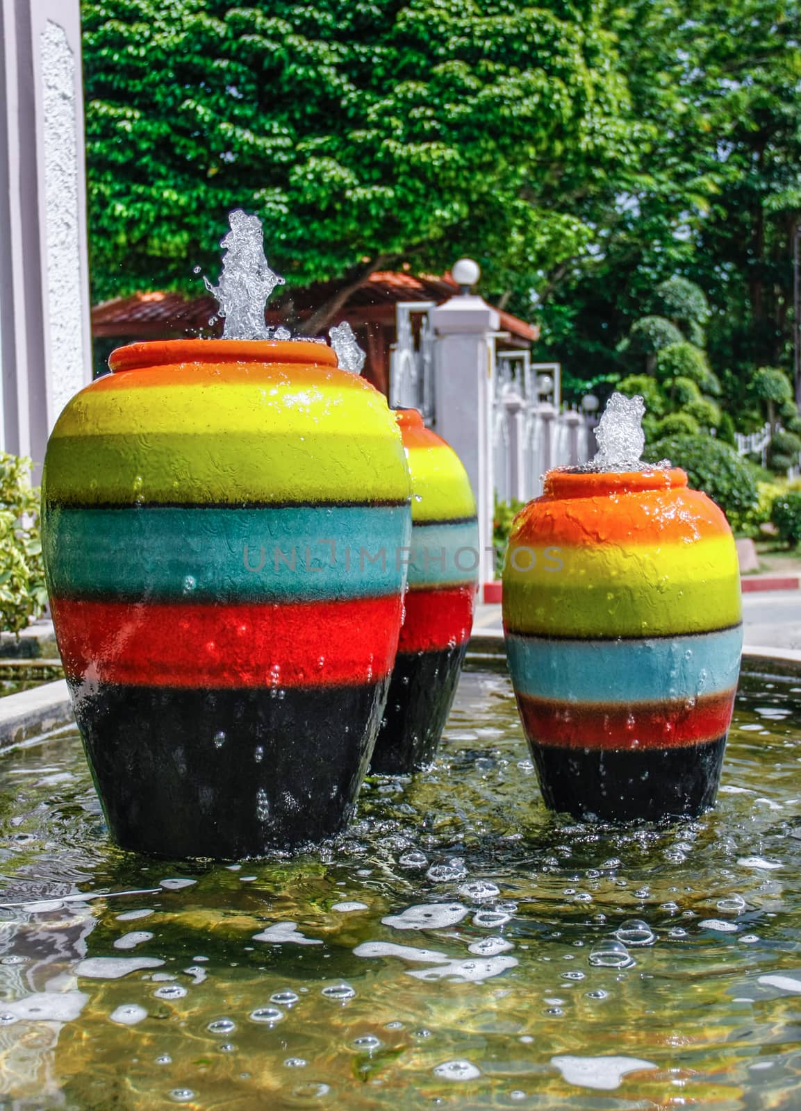 colorful jar pot fountain in pond front of entrance door