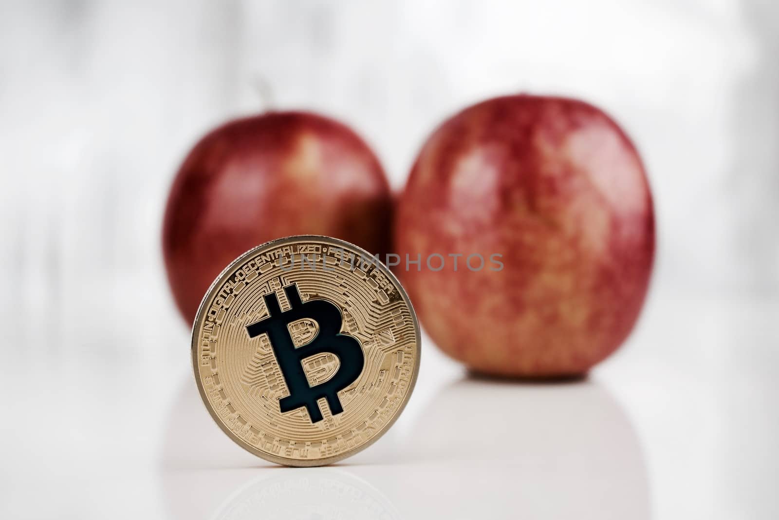 Digital currency physical gold bitcoin coin near apple.