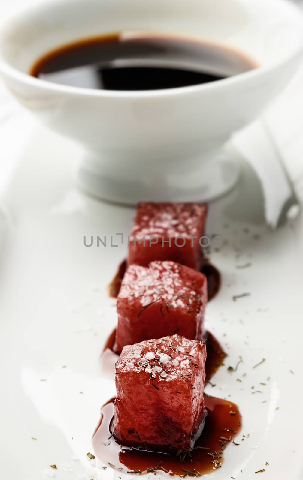 Tuna sashimi dipped in soy sauce,  thick salt and dill with sauce bowl. Raw fish in traditional Japanese style. Vertical  image.