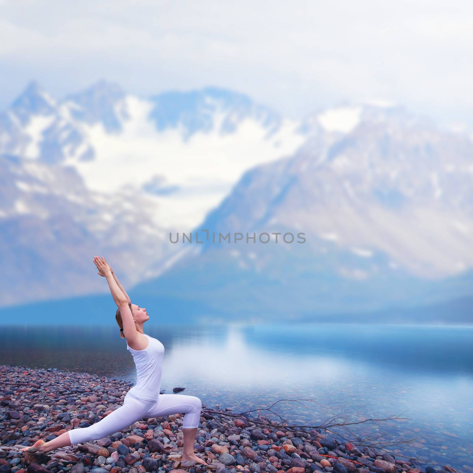 Young woman practice yoga on beach of foggy morning fjord in Norway