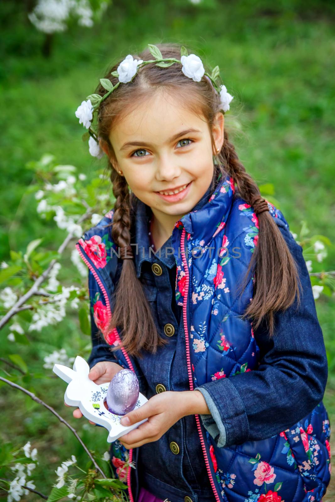 Smiling girl with easter toy rabbit at spring