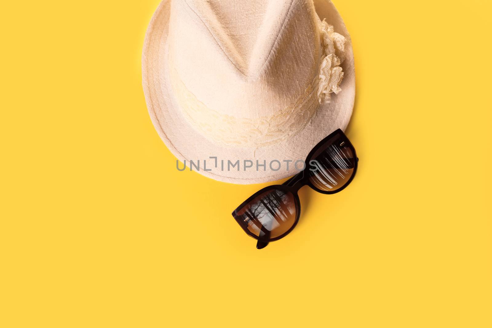 Summer woman's hat and glasses on a yellow background