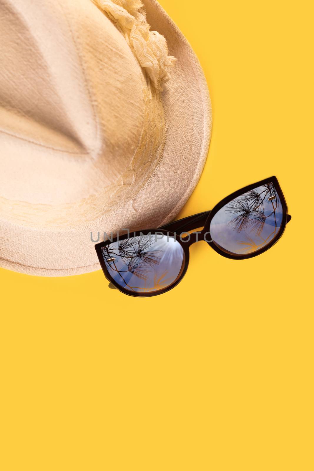 Summer woman's hat and glasses on a yellow background