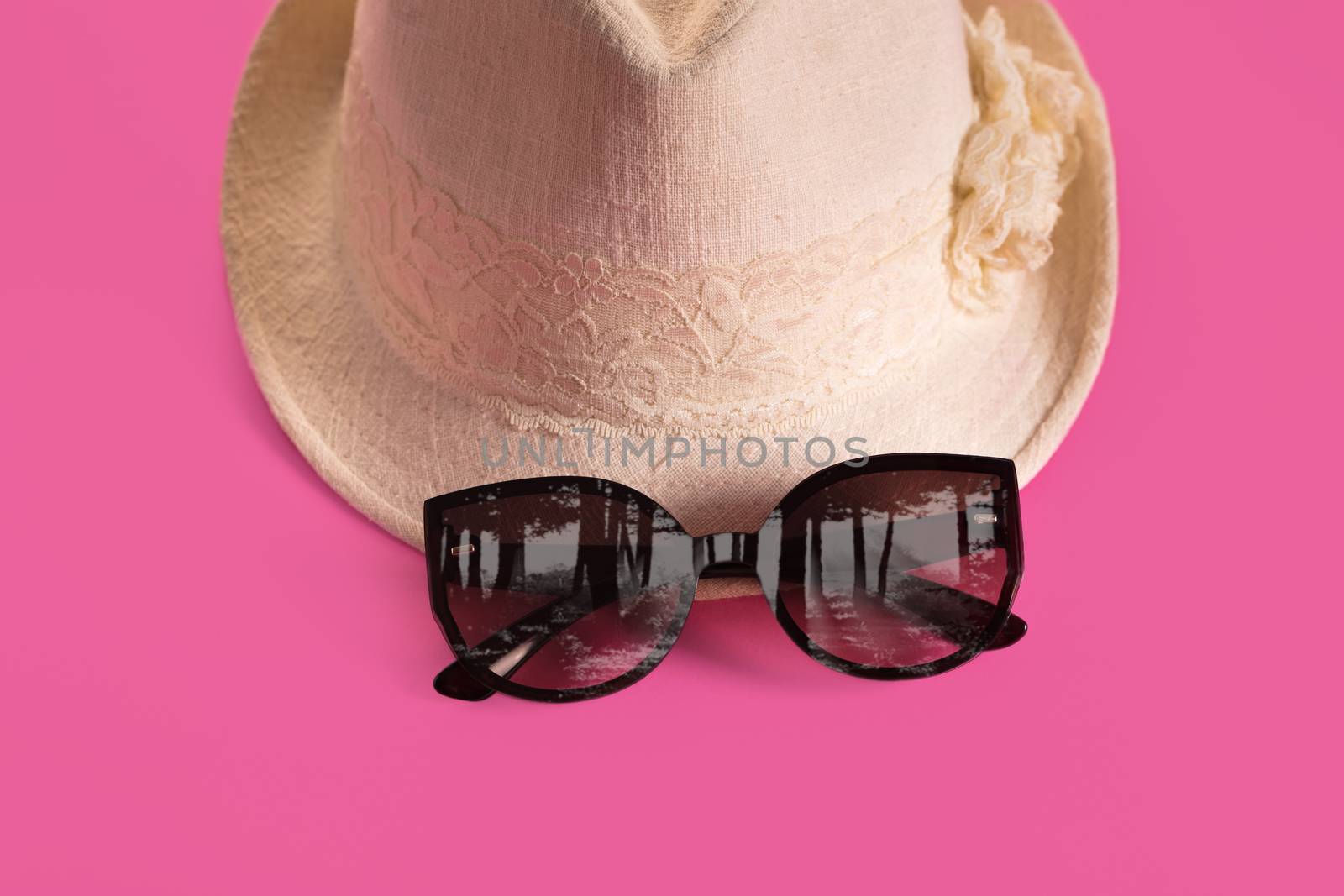 Summer woman's hat and glasses on a pink background