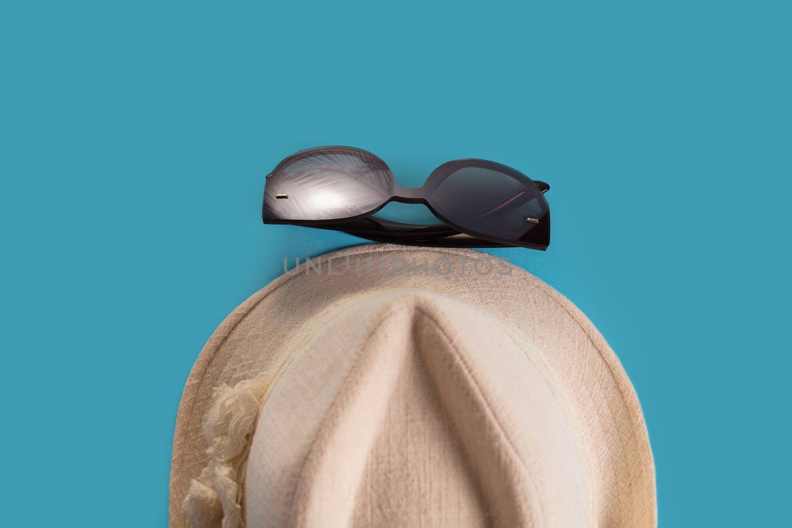 Summer woman's hat and glasses on a blue background