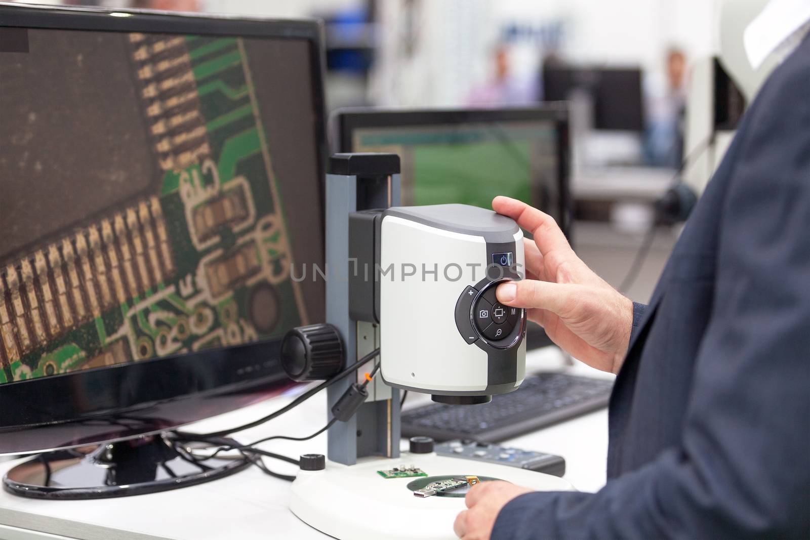 Operator working with digital microscope, inspecting electronic component