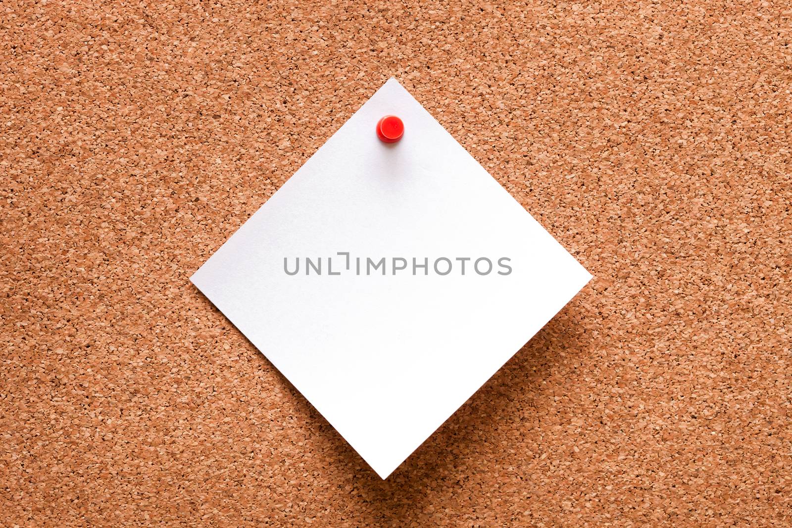 White paper with red clip nailed on wooden board.
