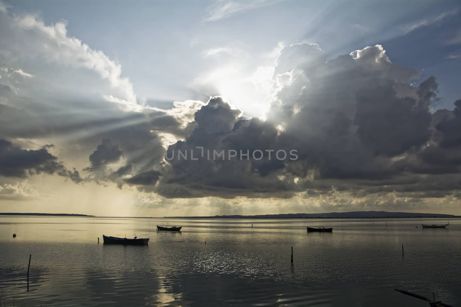 After the thunderstorm, sunset on the lagoon. In the background fishing boats. Mediterranean islands.