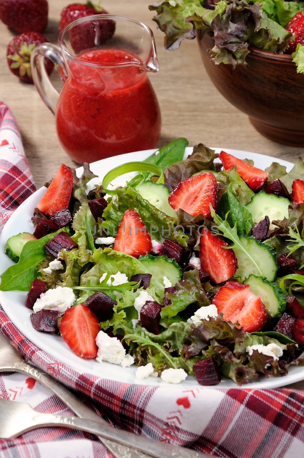 Salad of vinaigrette with strawberries, tender feta and strawberry sauce. Vertical shot.