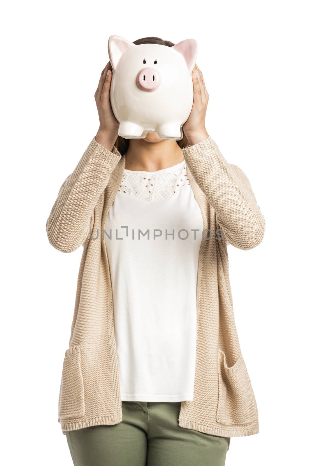 Beautiful and happy woman holding a piggy bank in front of her face