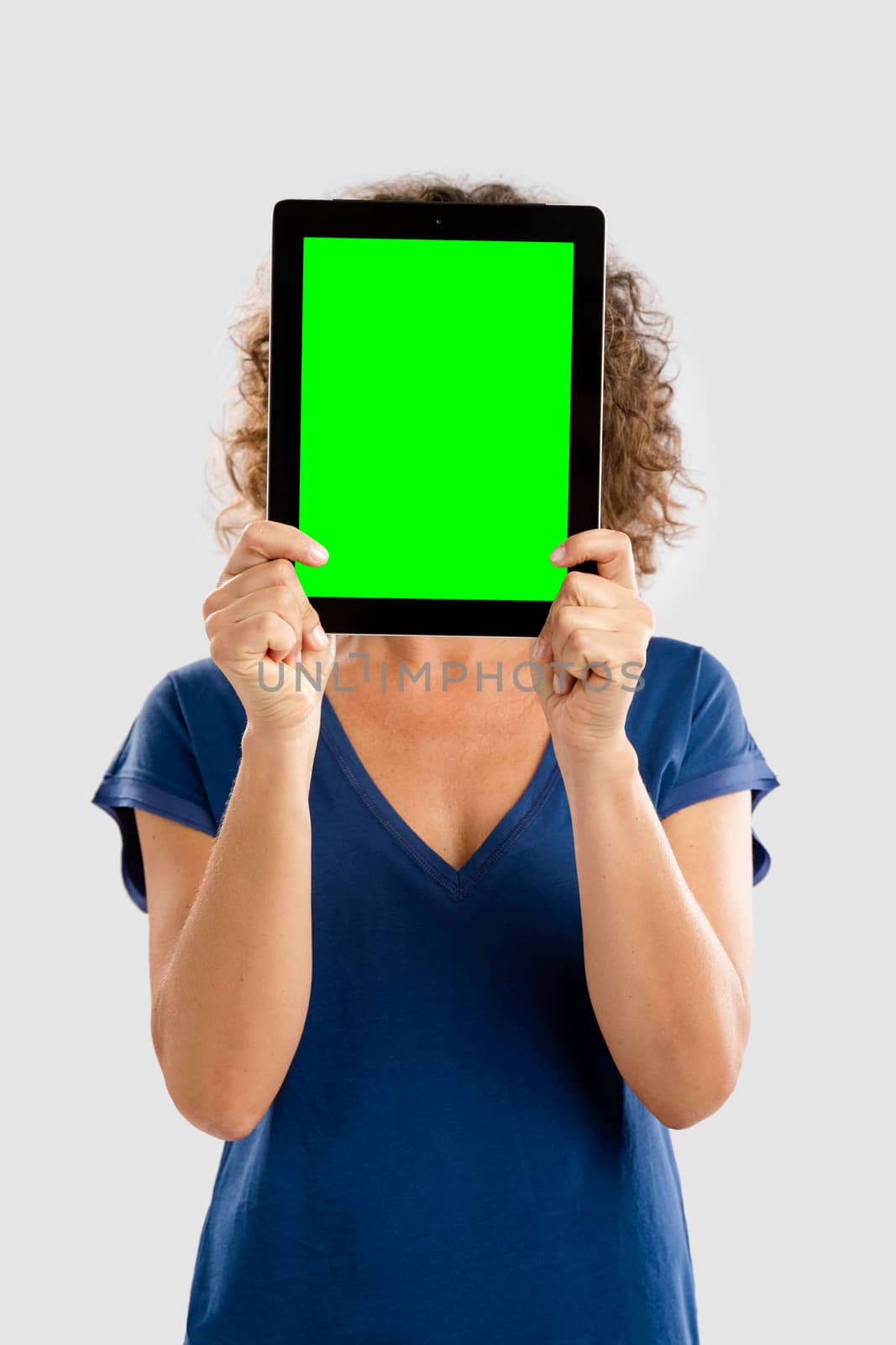 Beautiful middle aged woman holding and showing something on a tablet