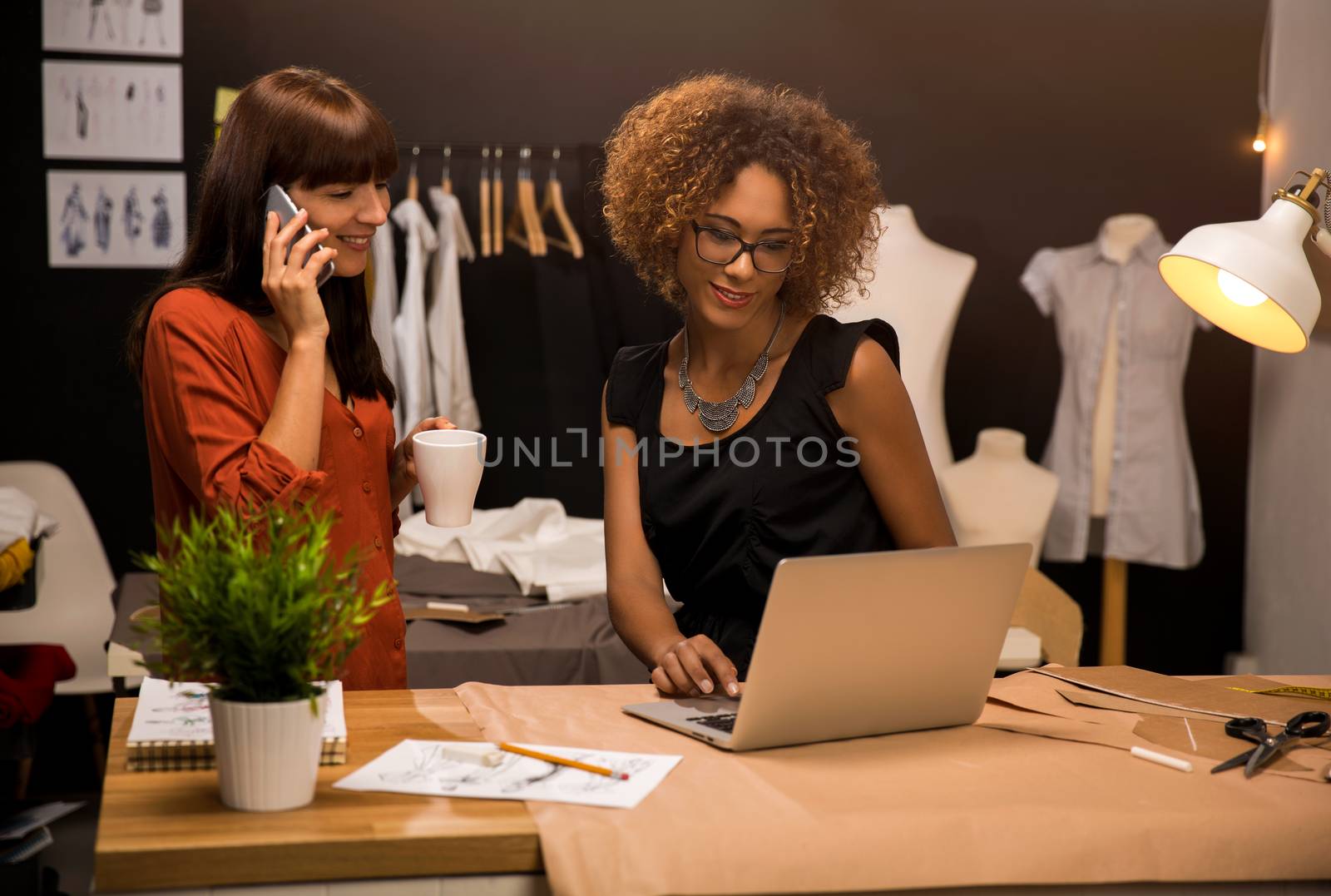 Two young entrepreneur women, and fashion designer working on her atelier