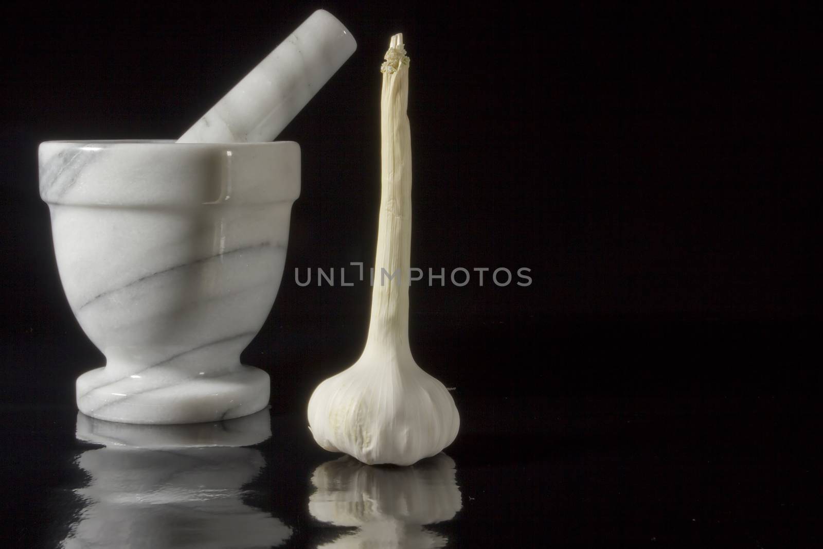 Garlic in mortar and pestle on a black background