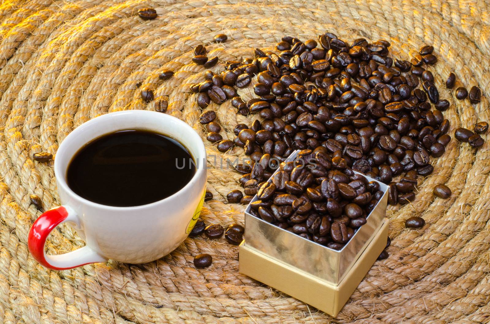 Cup of coffee with box gold Square on a jute rope.