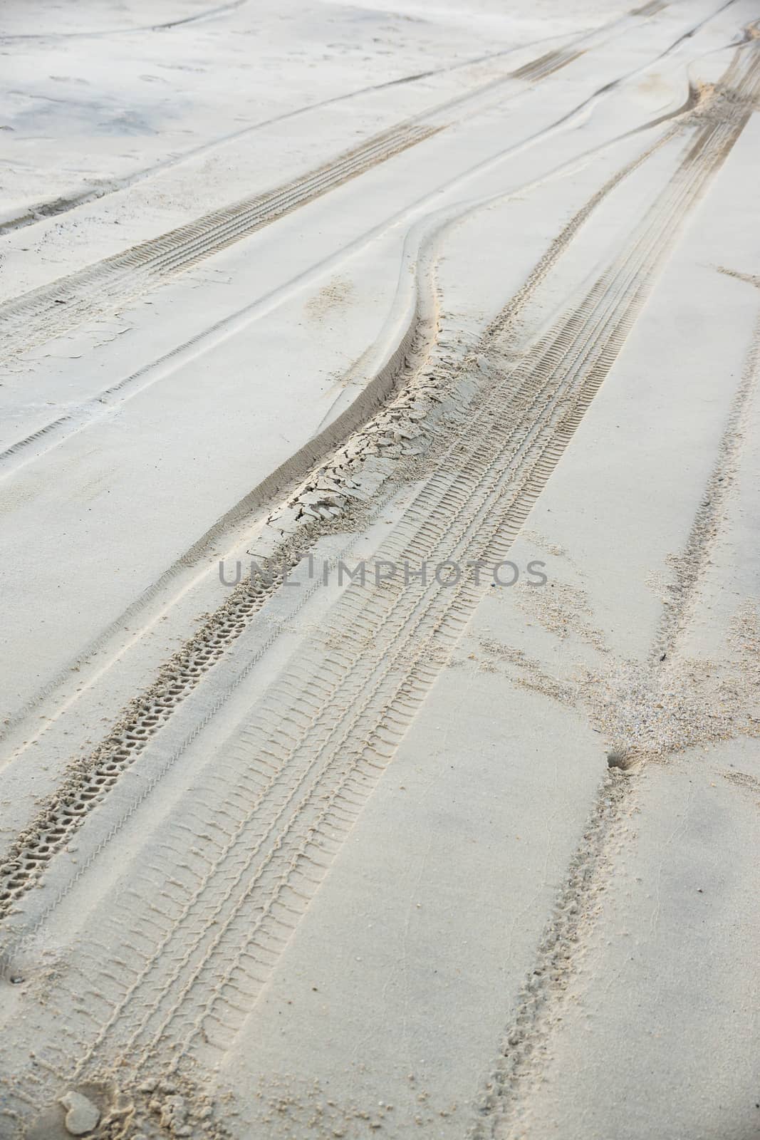 traces of tires traveling through the sand