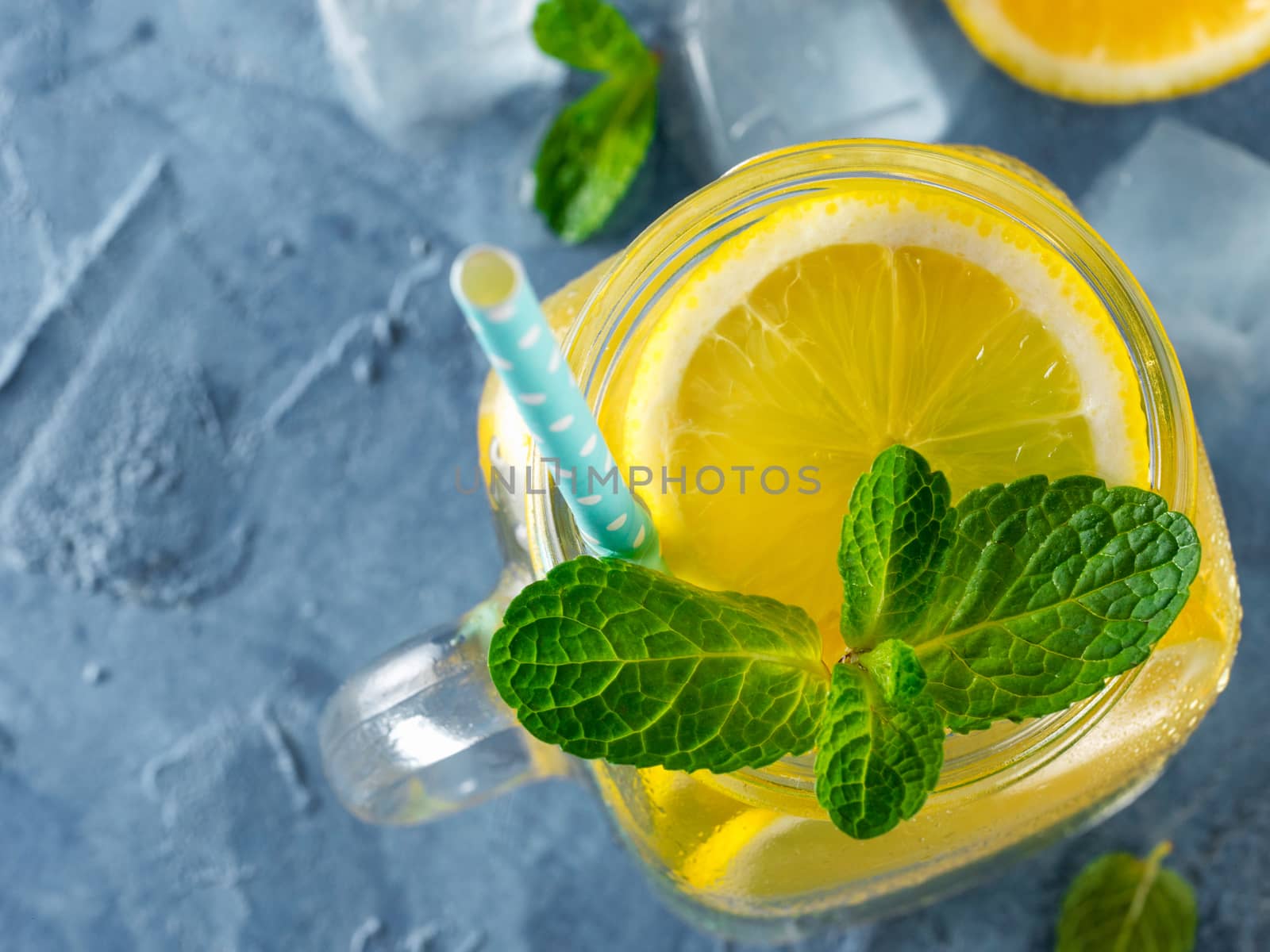 Lemonade with mint in mason jar on blue concrete background. Summer drink. Top view or flat lay. Copy space