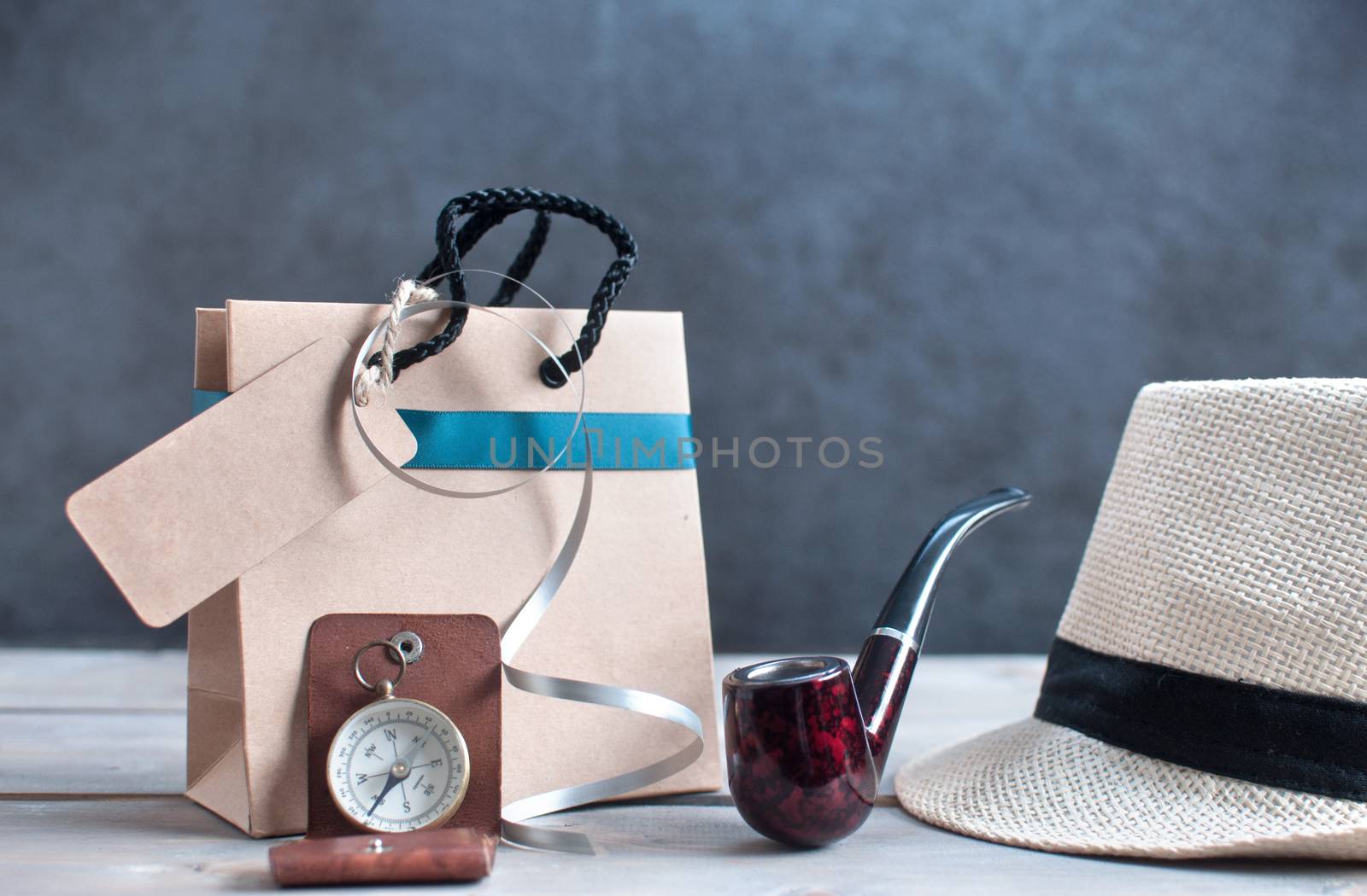 Gift bag with label alongside hat, pipe and compass