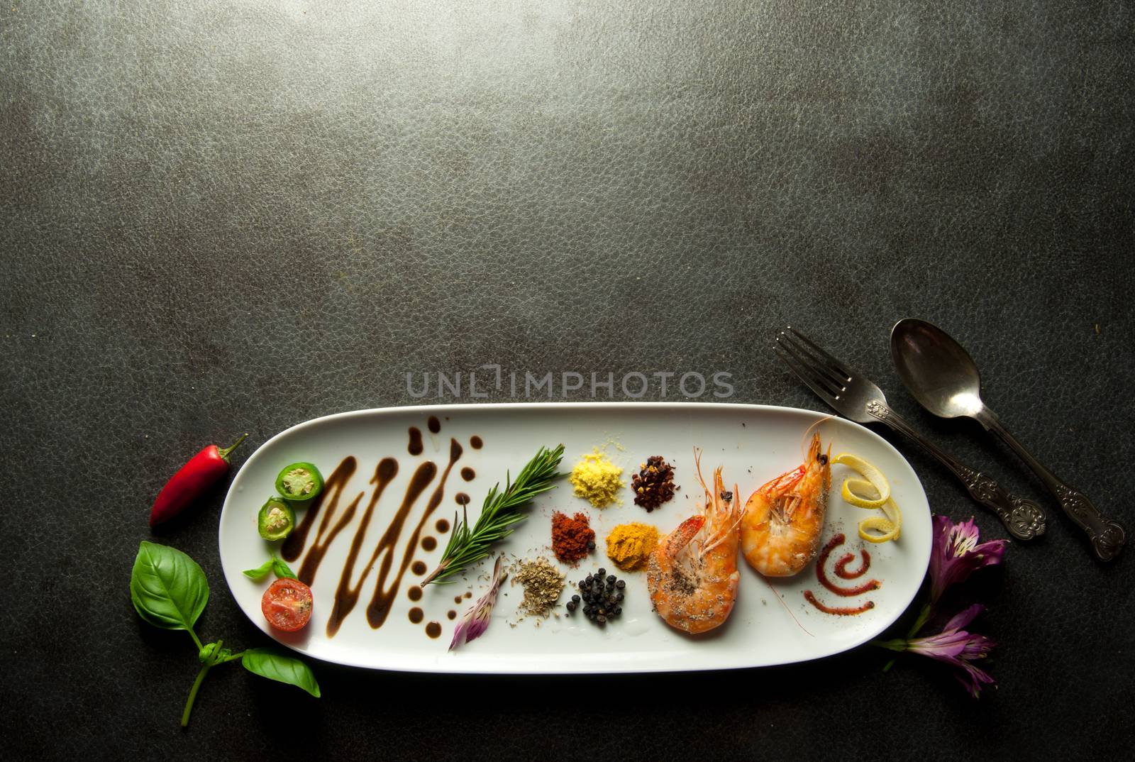 Herbs and spices on a plate with cooked prawns