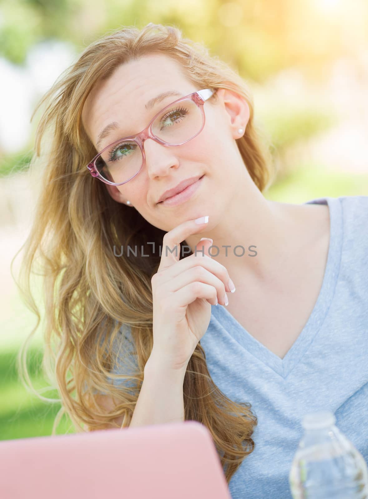 Young Adult Woman Wearing Glasses Outdoors Using Her Laptop.