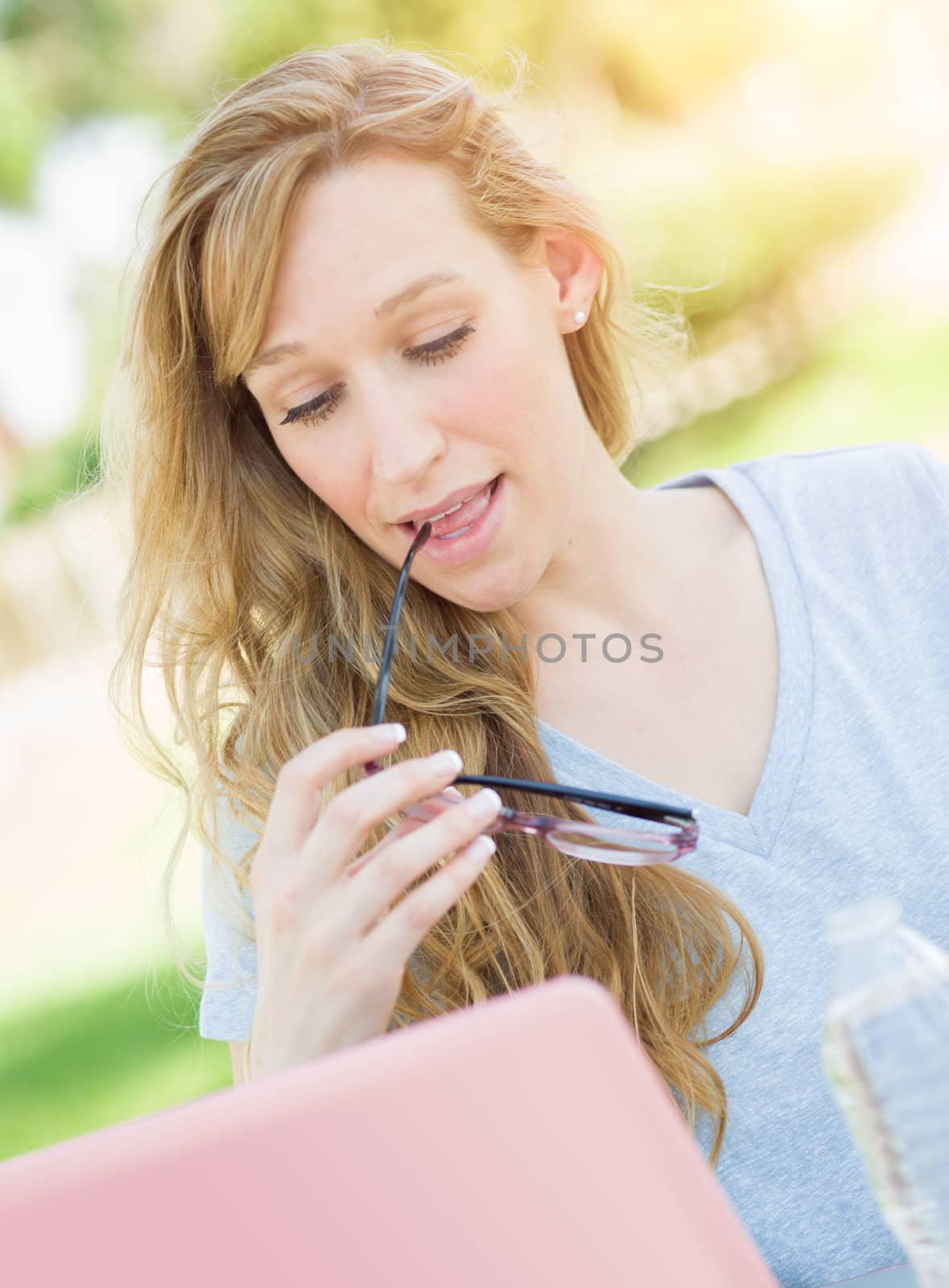 Young Adult Woman With Glasses Outdoors Using Her Laptop.