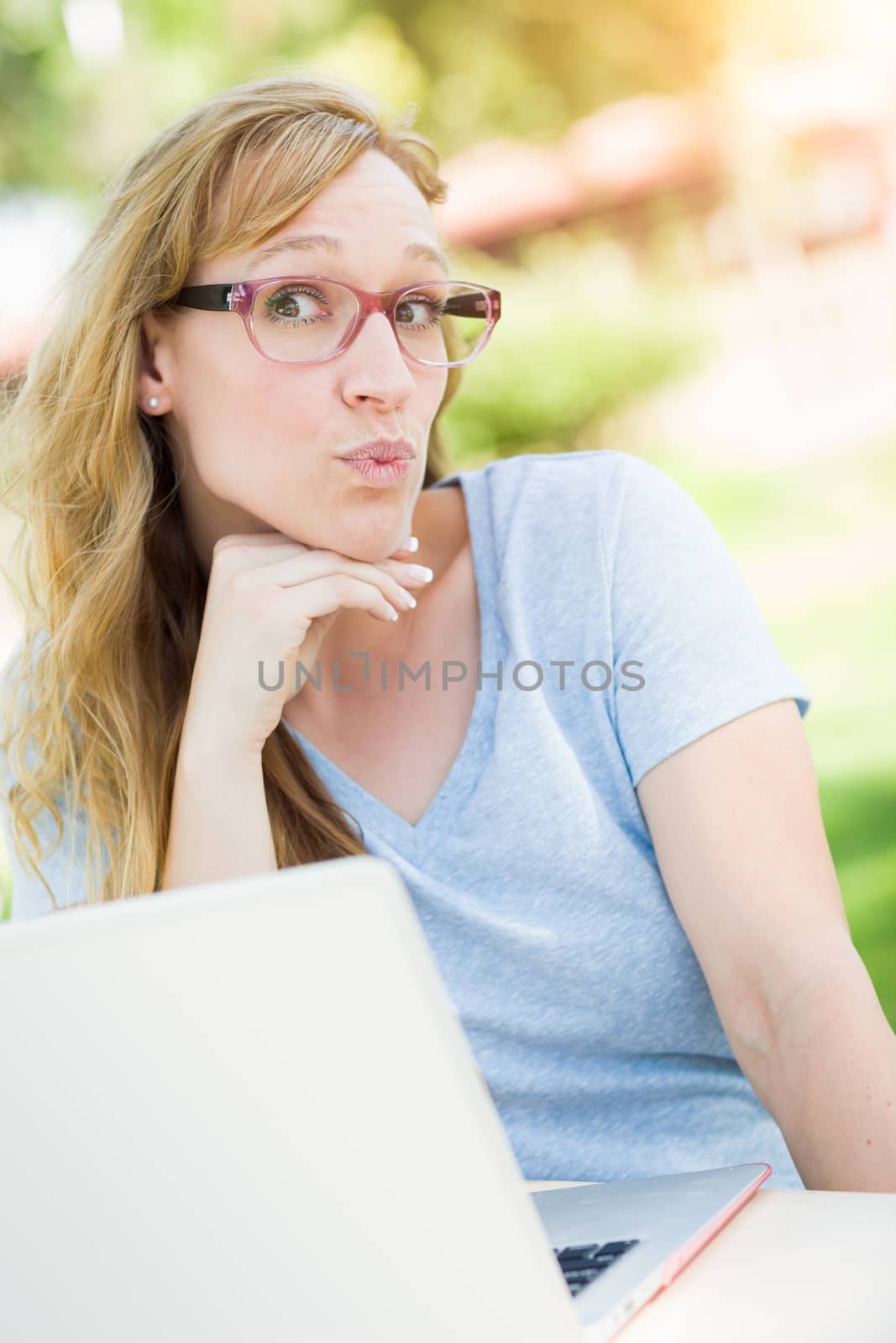 Young Adult Woman Wearing Glasses Outdoors Using Her Laptop.