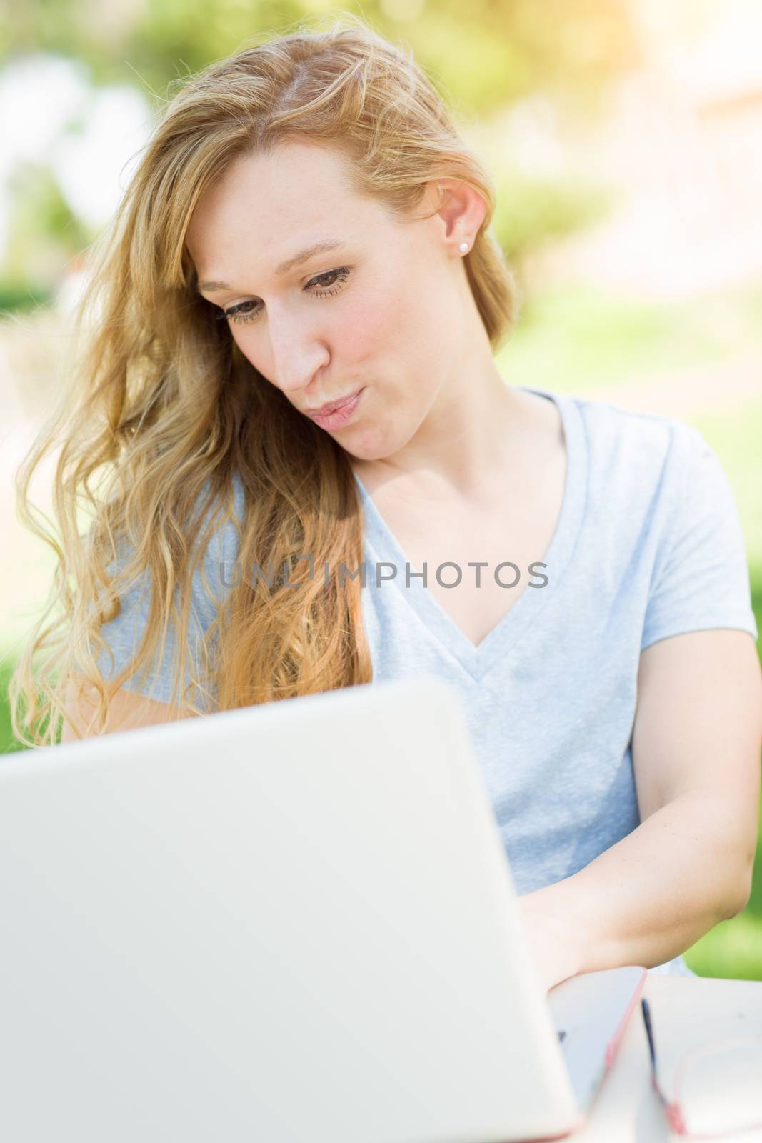 Young Adult Woman Live Video Chatting Outdoors Using Her Laptop.