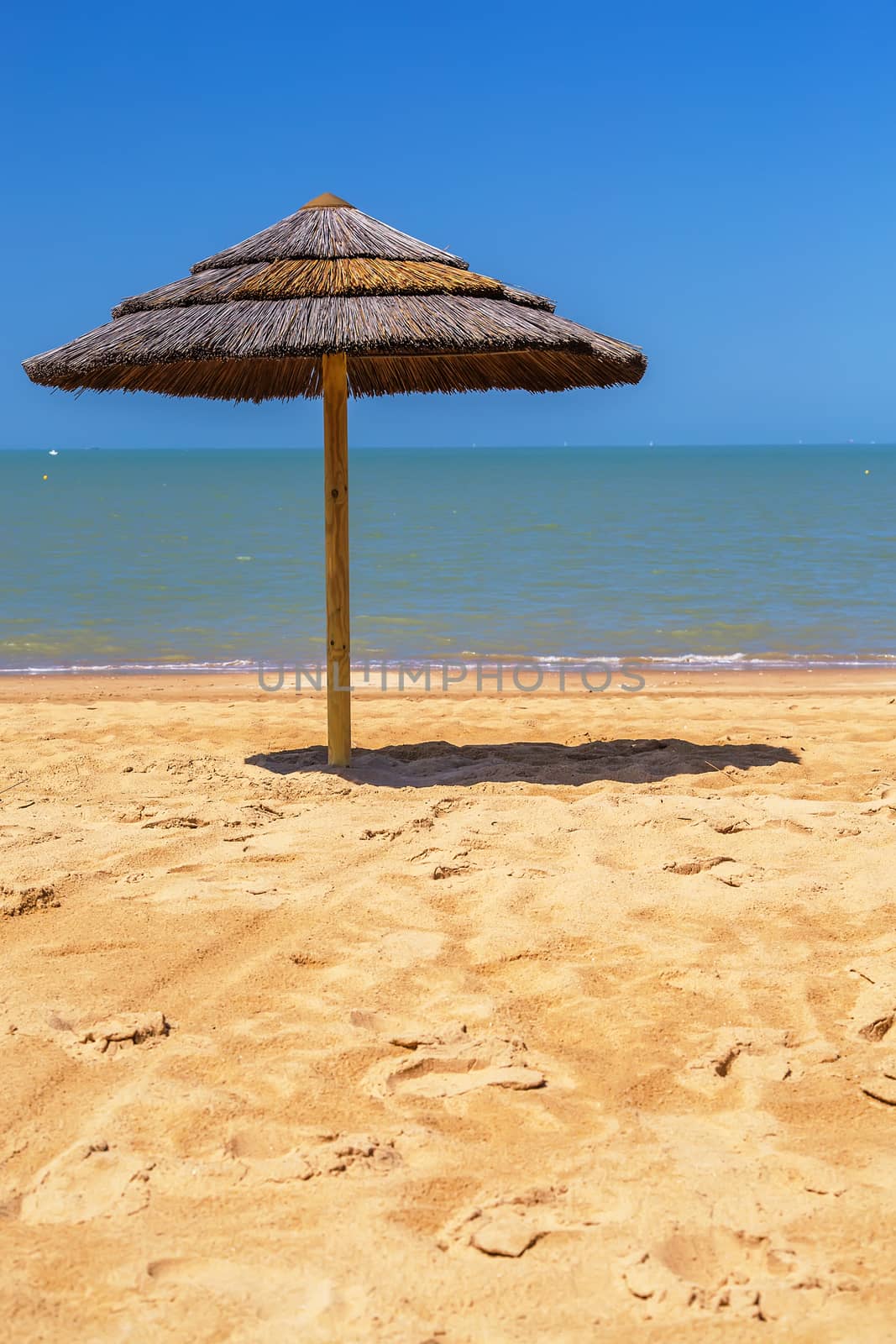 straw beach umbrella with blue sky