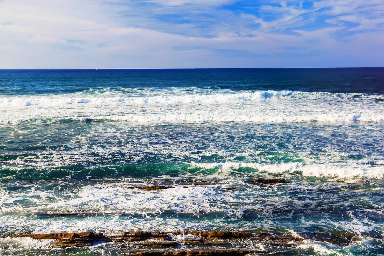 Seascape with rocks, foam and spray of the waves