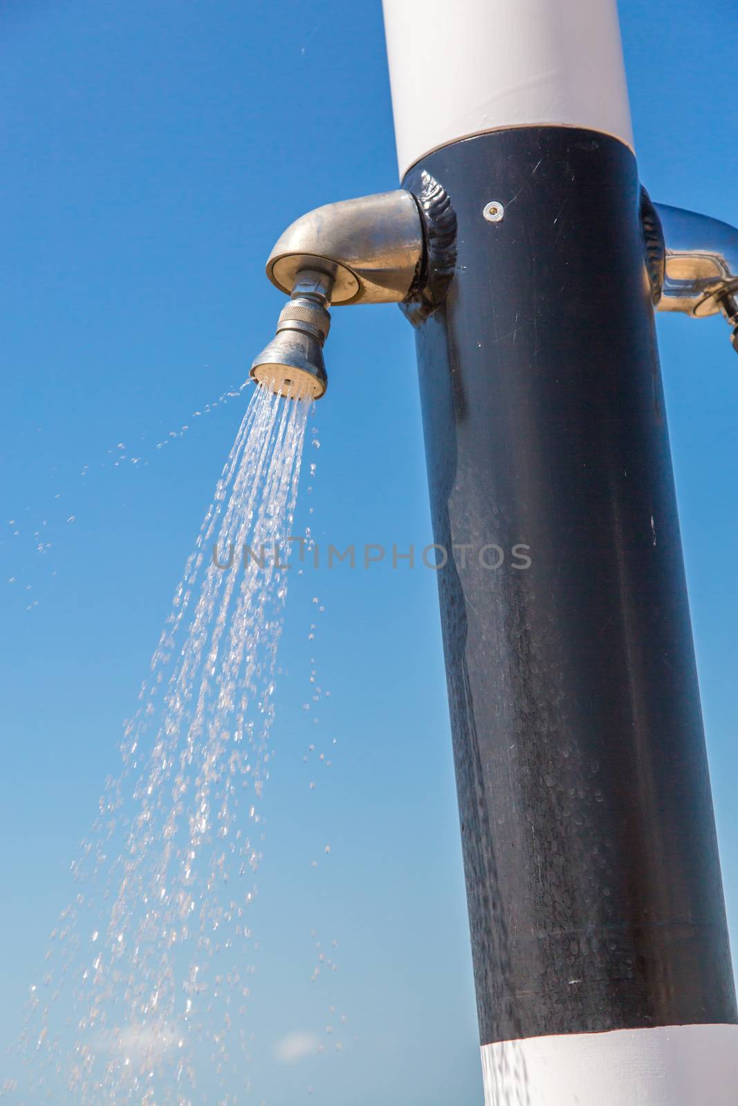 Water flowing from public shower on the beach by pixinoo