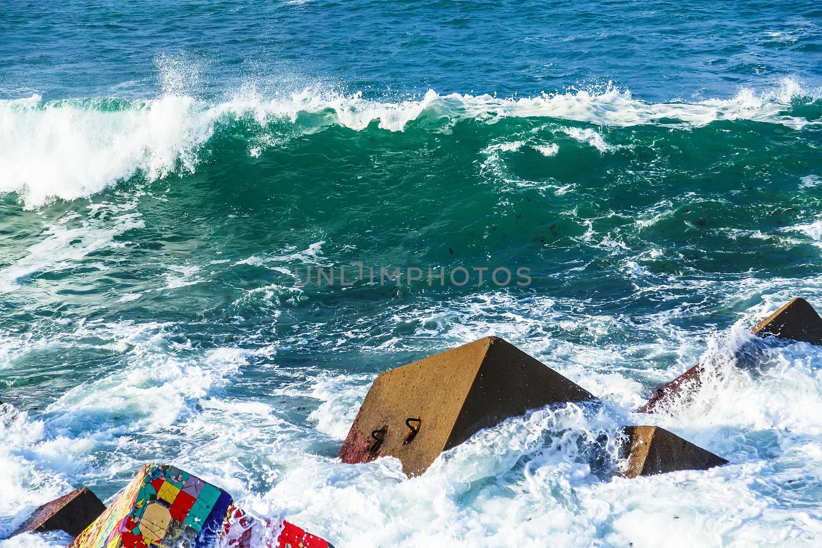 Seascape with coloreful rocks, foam and spray of the waves