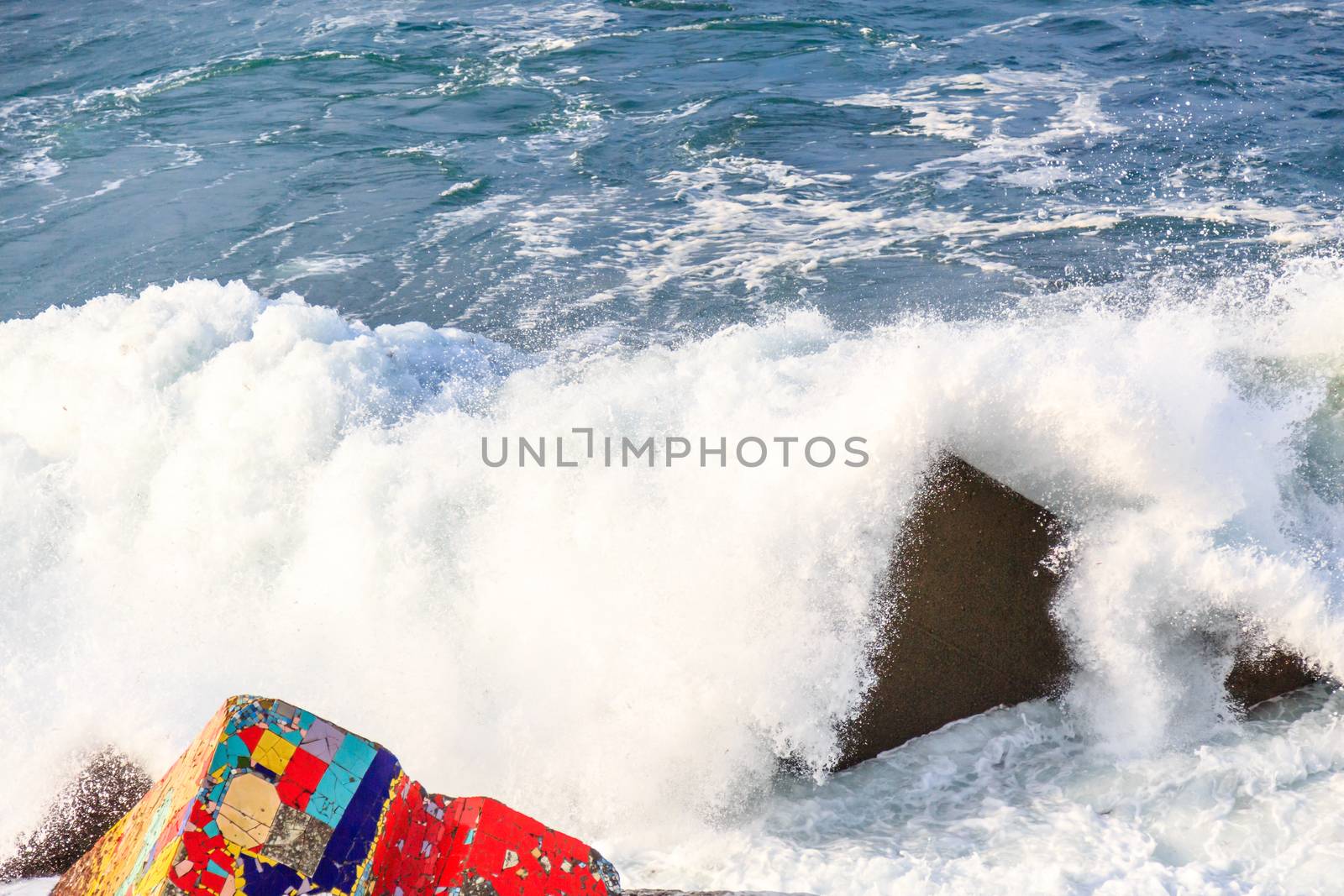 Seascape with coloreful rocks, foam and spray of the waves