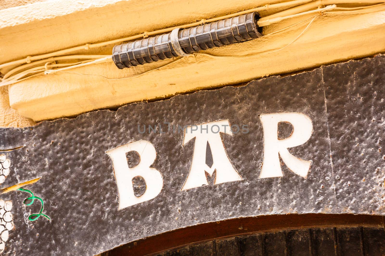 an old bar sign over a dirty wall