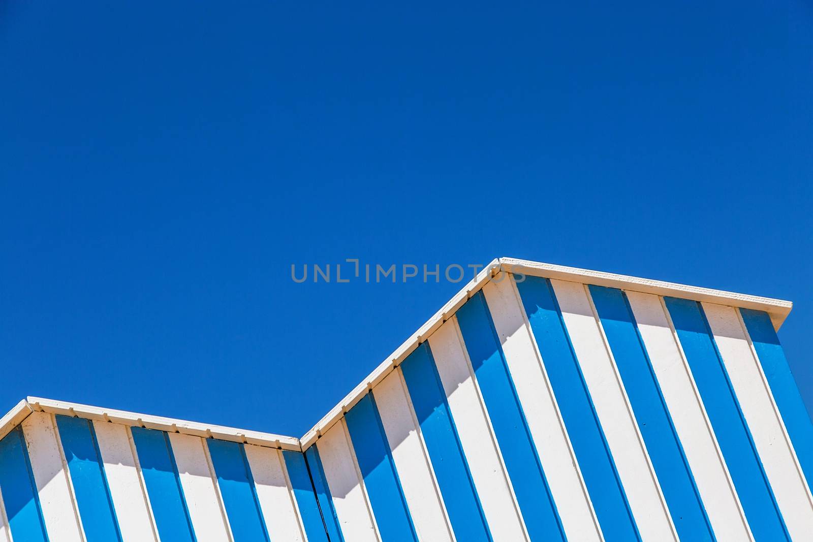 detail of cabin on a beach with blue sky on background by pixinoo