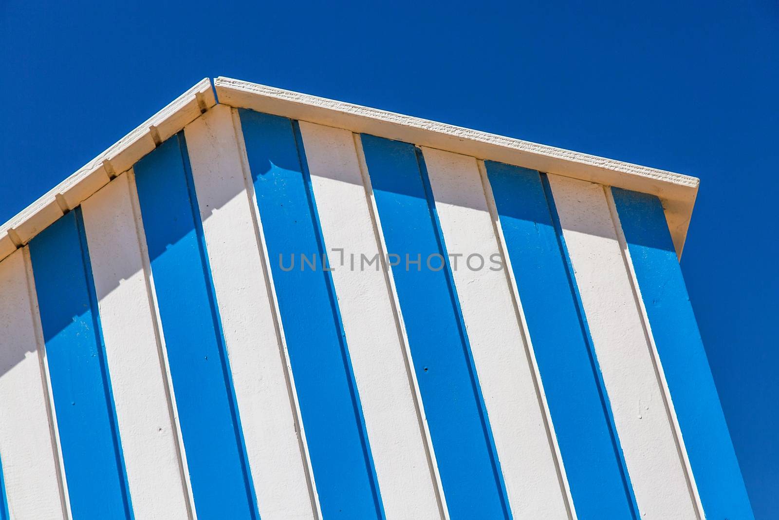 detail of cabin on a beach with blue sky on background by pixinoo