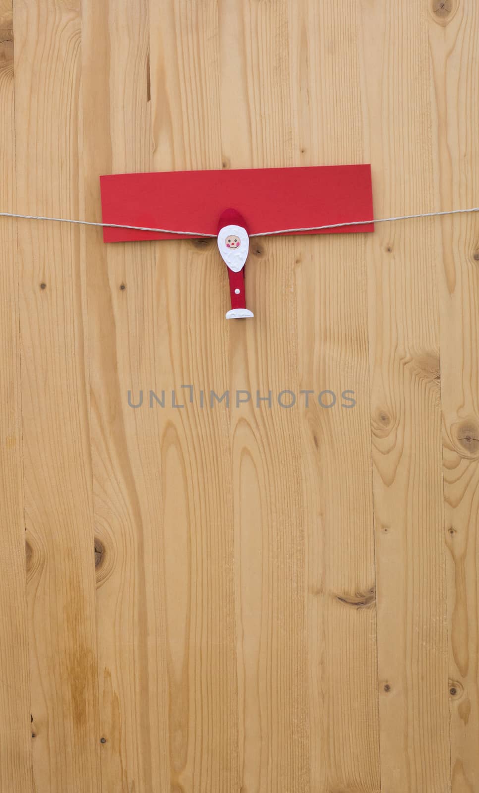 One christmas man with clothes pegs on a cord on wood